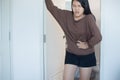 Asian woman having painful stomachache and diarrhea in front of toilet bowl after wake up, Female suffering from abdominal pain Royalty Free Stock Photo