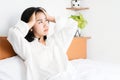 Asian woman having a problem with depression sitting in bed hand holding her head, overthinking and bad feeling Royalty Free Stock Photo