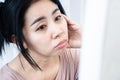 Asian woman having skin problem with dark under eye circles, bag eyes wrinkles checking her face in mirror Royalty Free Stock Photo