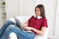 Asian woman with headphone using laptop computer with relax pose