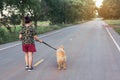 Asian woman with her golden retriever dog walking on the public road Royalty Free Stock Photo