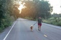 Asian woman with her golden retriever dog walking on the public road Royalty Free Stock Photo