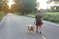 Asian woman with her golden retriever dog walking on the public road Royalty Free Stock Photo