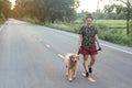 Asian woman with her golden retriever dog walking on the public road Royalty Free Stock Photo