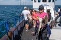 An Asian woman in her 50s on a family fishing trip shows her fresh catch of codfish. Blue sky in the background Royalty Free Stock Photo