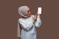 Asian woman in hijab was looking at the cell phone with her hand pointing at the phone screen Royalty Free Stock Photo