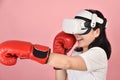 Asian woman hitting a punch by vr glasses, Working out with boxing video games application from virtual reality headset
