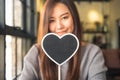 Asian woman holding a blank heart shape blackboard sign with feeling happy and in love Royalty Free Stock Photo