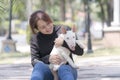 An Asian woman is holding a bull terrier. Young woman hug bull terriear dog