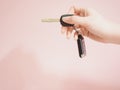 asian woman holding car key with car security control set by beauty right hand with pink pastel background Royalty Free Stock Photo