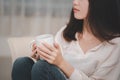 Asian woman holding a coffee mug with her stress, sadness, despair, sorrow, and facial expression