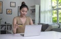 Asian woman holding credit card and using laptop computer. Businesswoman working at home. Online shopping, e-commerce Royalty Free Stock Photo