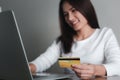 Asian woman holding credit card and using laptop computer, e-commerce, internet banking, Online shopping and spending via credit