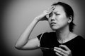 Asian woman holding glasses, suffer from having a strong headache and fever, poor sight, farsightedness, myopia. Black and white Royalty Free Stock Photo