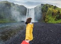 Asian woman holding hands with couple at front of SkÃÂ³gafoss waterfall flowing on cliff in summer at Iceland Royalty Free Stock Photo