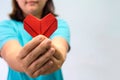 An asian woman holding heart origami in front of her chest. A woman giving red heart paper to someone. Love and give concept for v