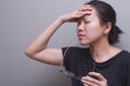 Asian woman holding her head, suffer from having a strong headache and fever, poor sight, farsightedness, myopia