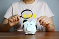 Asian woman holding magnifying glass in hand looking  piggy bank with illustration star , saving money concept Royalty Free Stock Photo