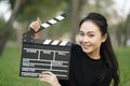 Asian woman holding movie clapper board in her hands, entertainment film concept Royalty Free Stock Photo
