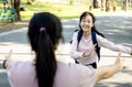 Asian woman holding opened arms and child girl daughter missed her mom running to mother standing in outdoor at primary school, Royalty Free Stock Photo