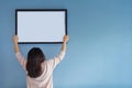 Asian woman holding a picture frame on blue wall. Royalty Free Stock Photo