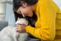 Asian woman holding and play with little cat with happiness at home. Attractive beautiful female sit on sofa, spend leisure free Royalty Free Stock Photo