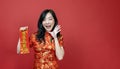 Asian woman holding red fortune blessing Chinese word which means to be blessed by a lucky star isolated on red background