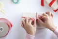 Asian woman holding red gift box on the hands offer to you on christmas tree background