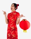 Asian woman holding red lantern in red cheongsam dress and pointing something isolated on white background. Chinese new year Royalty Free Stock Photo