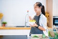 Asian woman holding salad bowl and eat vegetable, she wears casual clothes. Diet and Healthy food concept Royalty Free Stock Photo