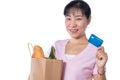 Asian woman holding a shopping bag full of groceries and credit Royalty Free Stock Photo