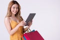 Asian woman holding shoppingbag and shopping online on teblet