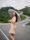 Asian woman holding umbrella on extremely curved road in mountain. Nan, Thailand. sky road on hill. Royalty Free Stock Photo