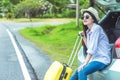 Asian woman holding a wheel suitcase bag