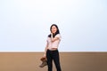 Asian woman holds brown boots in her hand and posting for photo shooting at rooftop environment at twilight time Royalty Free Stock Photo