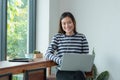 Asian woman influencer using on laptop computer near window at c Royalty Free Stock Photo