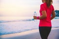 Asian women jogging workout on the beach in the morning. Relax with the sea walk and drinking water from the plastic bottles Royalty Free Stock Photo