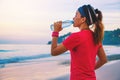 Asian women jogging workout on the beach in the morning. Relax with the sea walk and drinking water from the plastic bottles Royalty Free Stock Photo