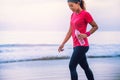 Asian women jogging workout on the beach in the morning. Relax with the sea walk and drinking water from the plastic bottles Royalty Free Stock Photo