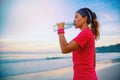 Asian women jogging workout on the beach in the morning. Relax with the sea walk and drinking water from the plastic bottles Royalty Free Stock Photo