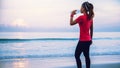 Asian women jogging workout on the beach in the morning. Relax with the sea walk and drinking water from the plastic bottles Royalty Free Stock Photo