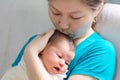 Asian woman kissing and holding infant baby in her arms, happy motherhood Royalty Free Stock Photo