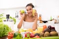 Asian woman in a kitchen with fruits and vegetables and juice