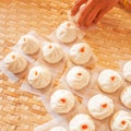 Asian woman is laying Baozi or Bun on bamboo basket