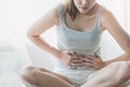 Asian woman laying on the bed suffering from abdominal pain. female suffering from period on the bed