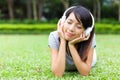 Asian woman listen to song lying on grass
