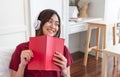 Asian woman listening music on headphone and reading book with r Royalty Free Stock Photo