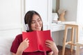 Asian woman listening music on headphone and reading book with r Royalty Free Stock Photo