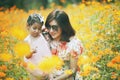 Asian woman and little girl happiness emotion in yellow cosmos flower blooming field Royalty Free Stock Photo