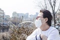 Asian woman looking at hazy sky. Wearing protection mask.